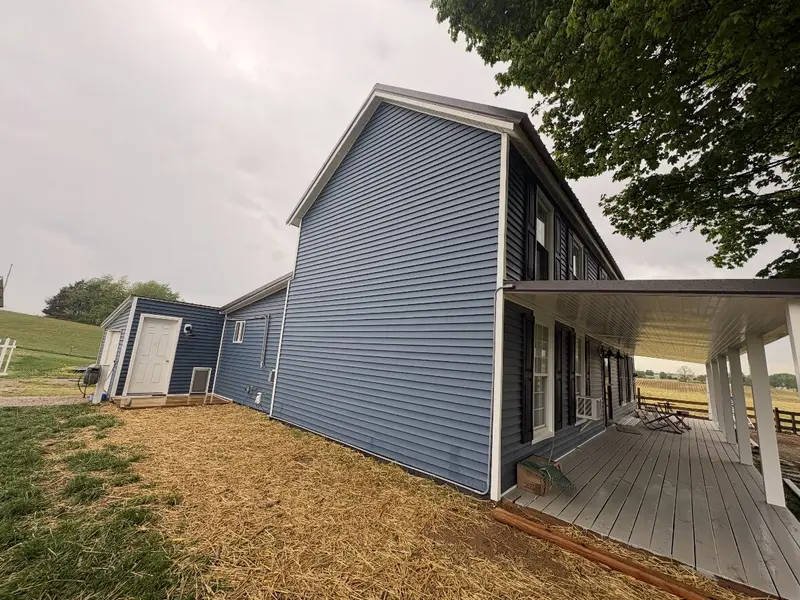 Finished navy vinyl siding and new porch on a Radcliff, KY home by RenovateX LLC